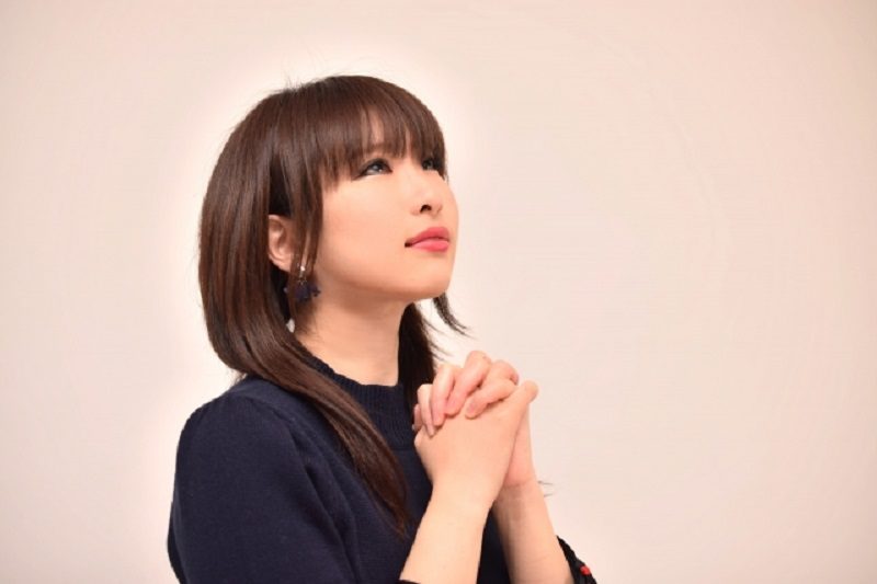 天に祈る女性