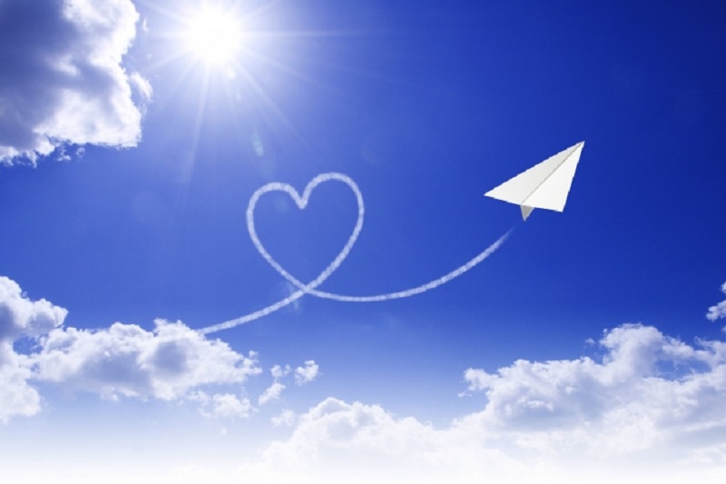 大空を舞い天に届く紙飛行機