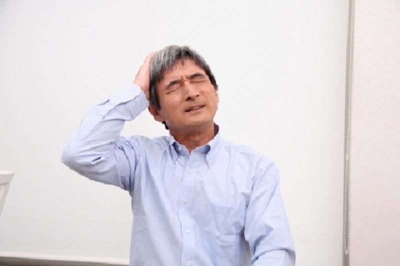 頭を抱える男性