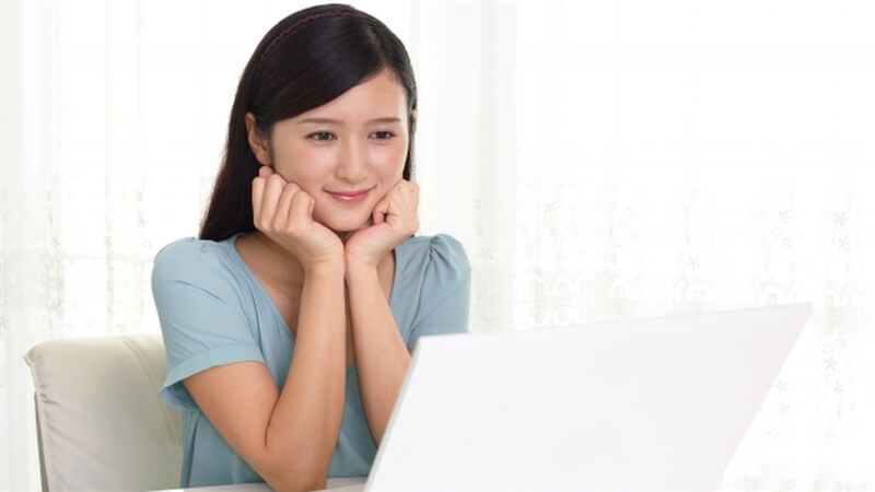 パソコンの前で笑顔の女性